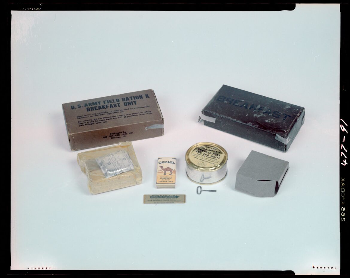 Rozložená polní dávka K-Ration se snídaňovou konzervou šunky a vajec, suchary, kávou a cigaretami