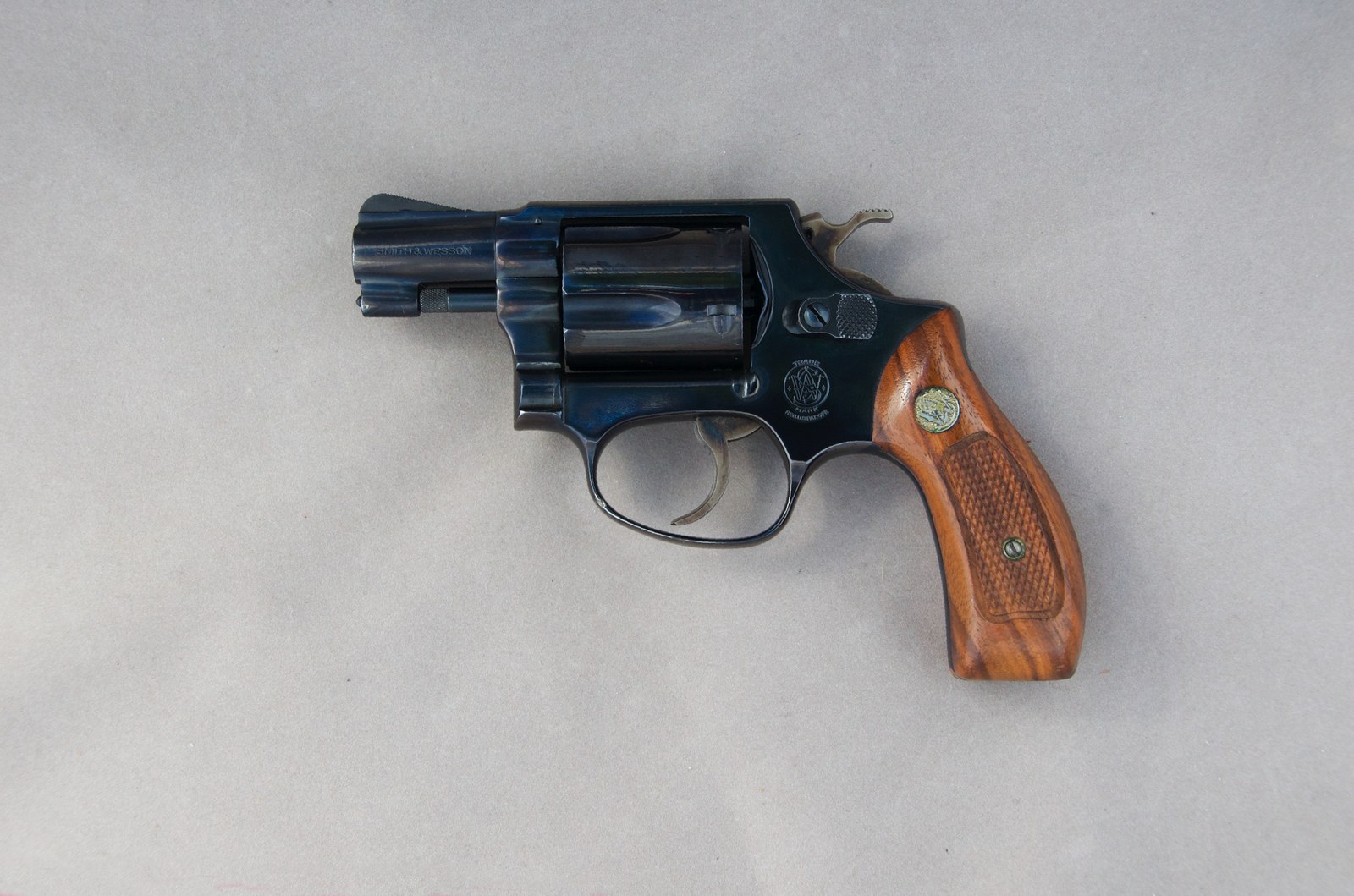 Kompaktní ocelový revolver Smith & Wesson třicet osm Special s dřevěnými střenkami.