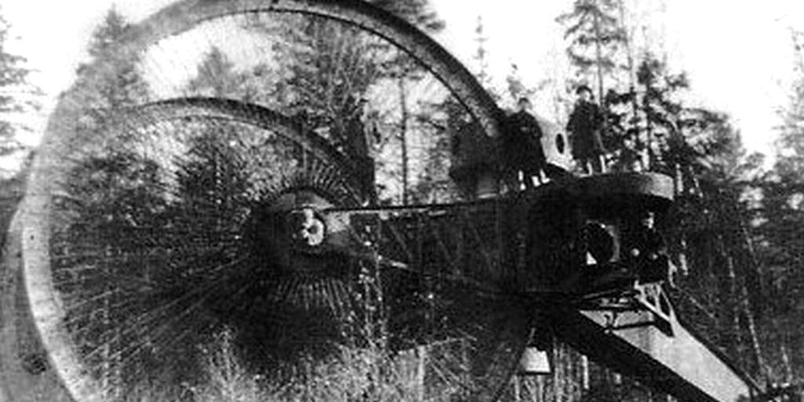 Dobová černobílá fotografie prototypu carského tanku Lebeděnko s obřími koly v lese.
