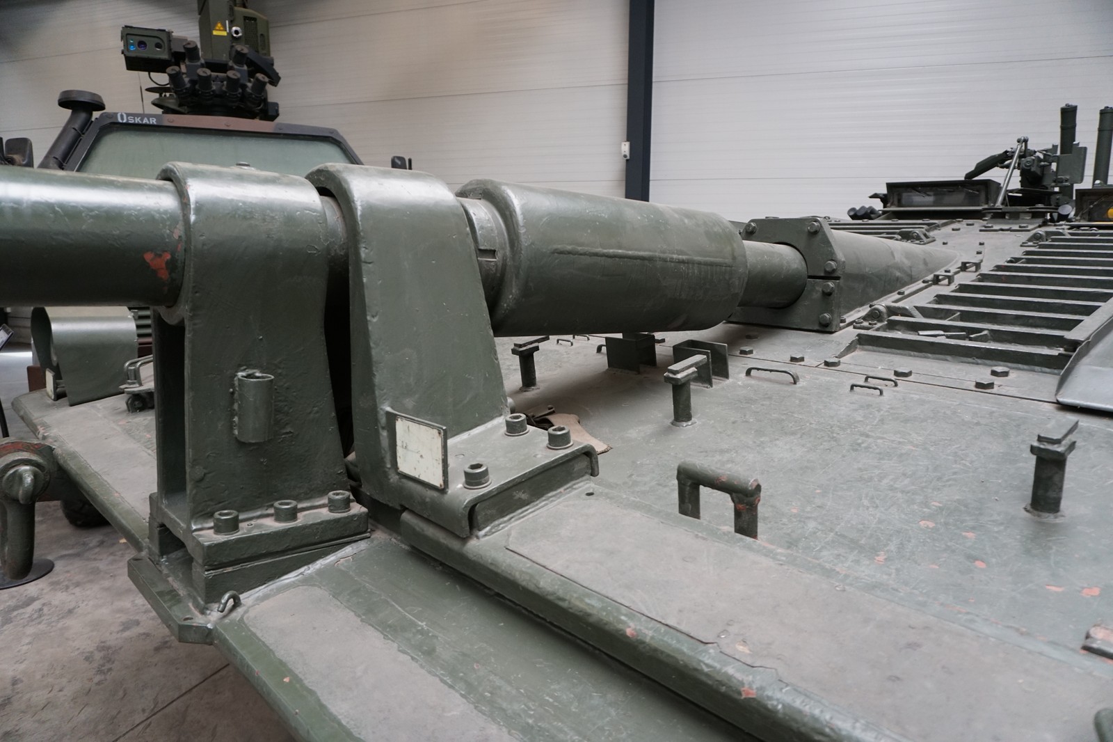 Detailní pohled na ostře skloněný čelní pancíř s žebrováním a pevnou hlaveň tanku Stridsvagn 103