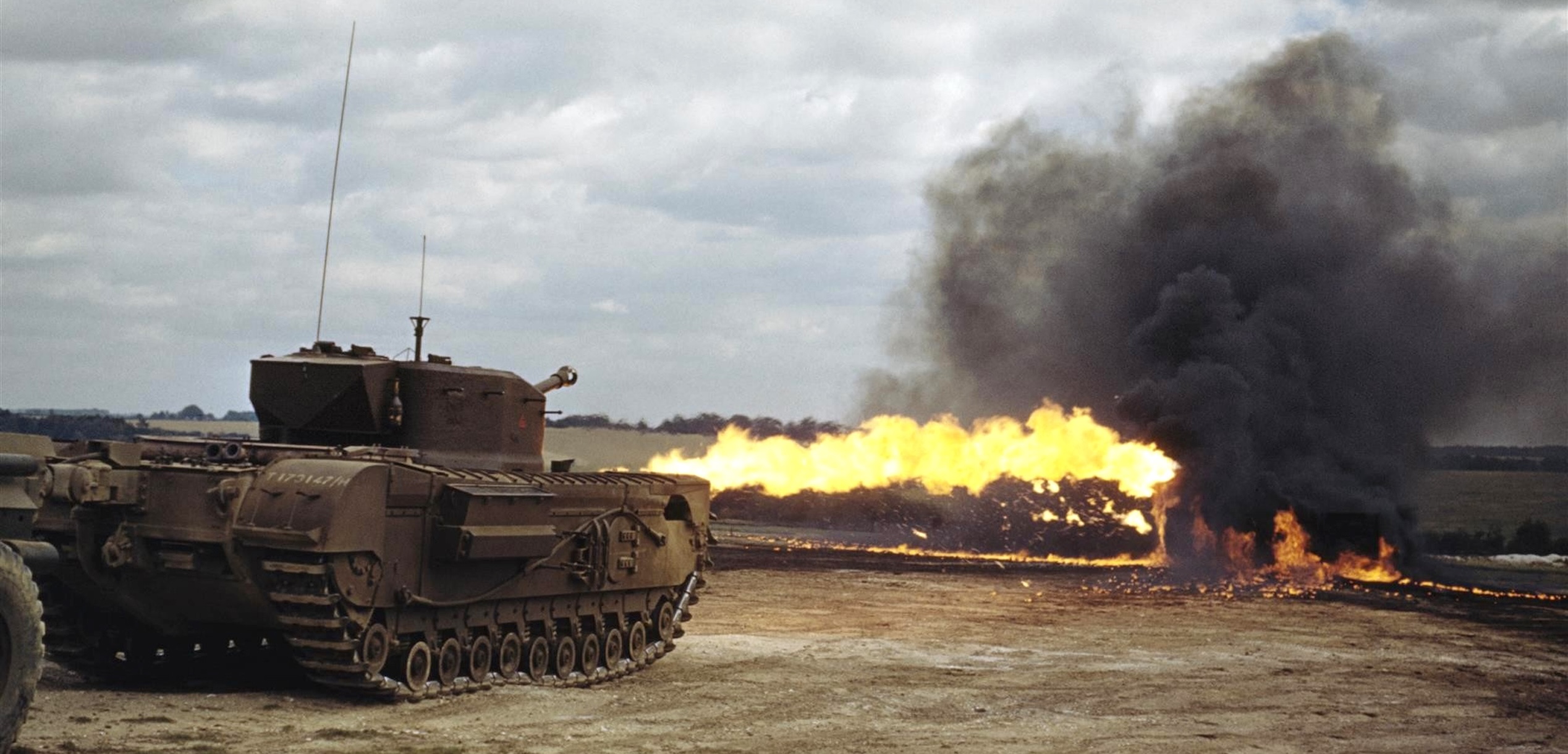 Pohled na těžký tank táhnoucí za sebou dvoukolový pancéřovaný přívěs.