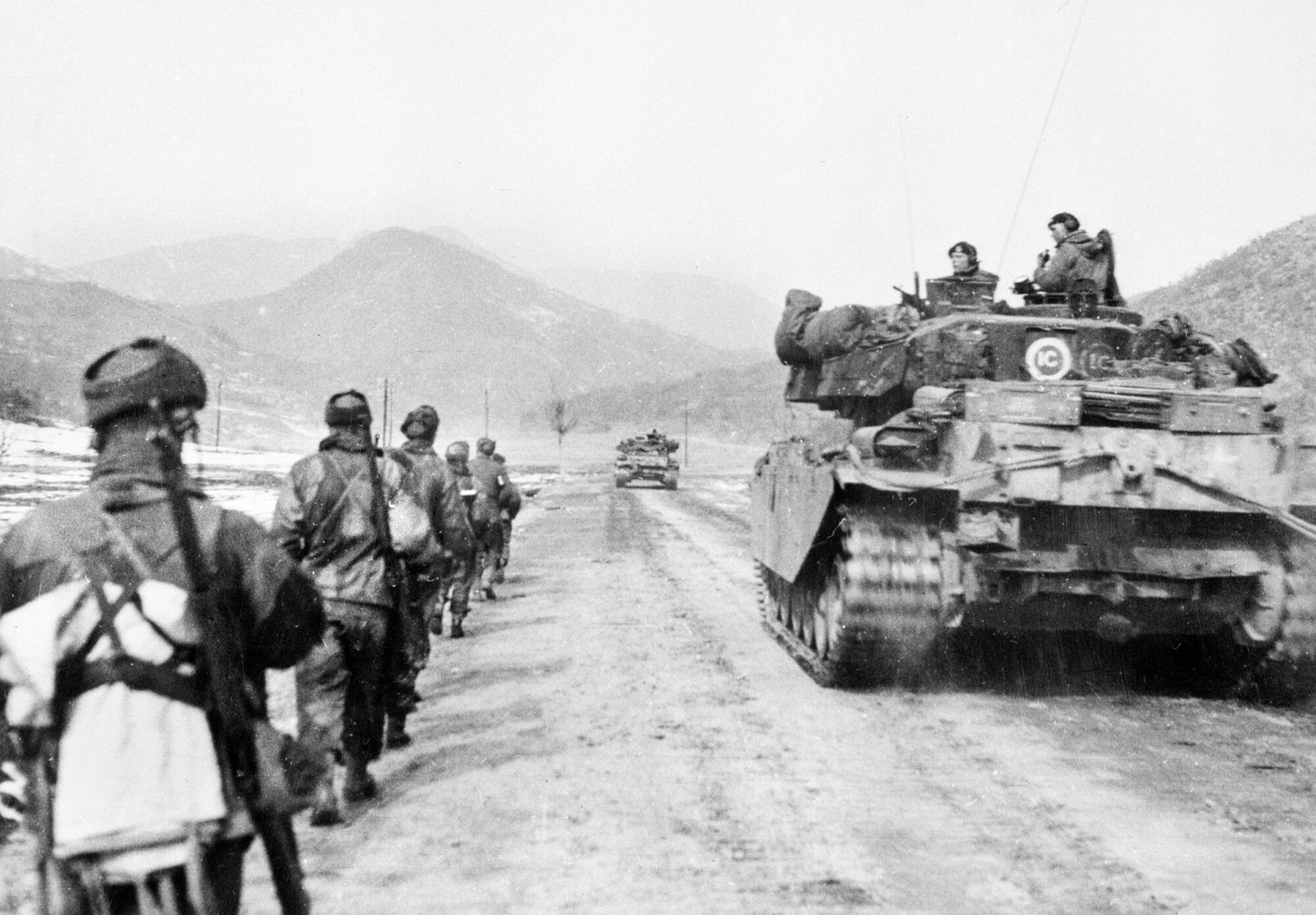 Tanky Centurion projíždějí členitým terénem v doprovodu pěchoty během války v Koreji