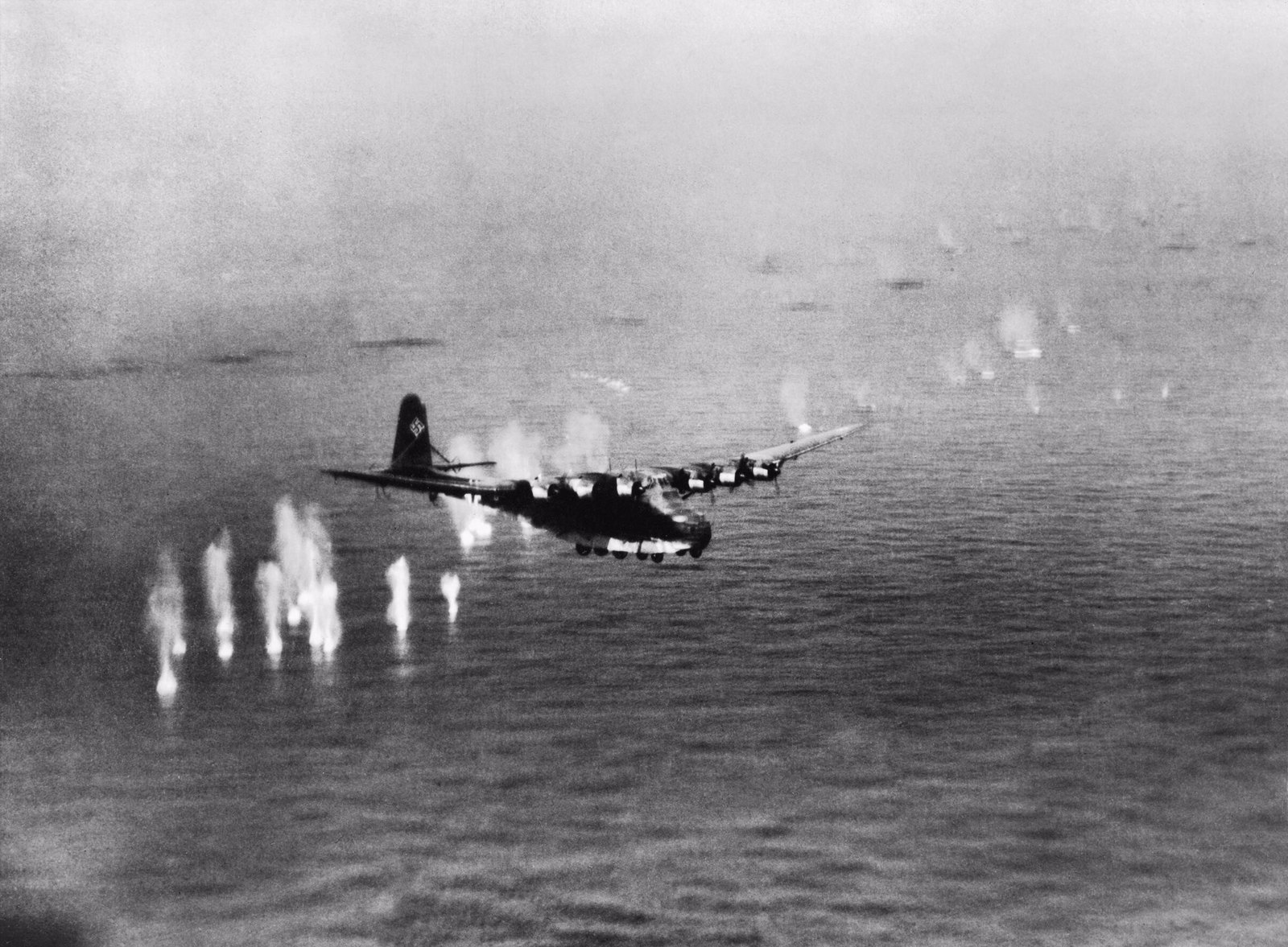 Transportní letoun Messerschmitt Me 323 letící nízko nad hladinou Středozemního moře pod palbou britského bombardéru.