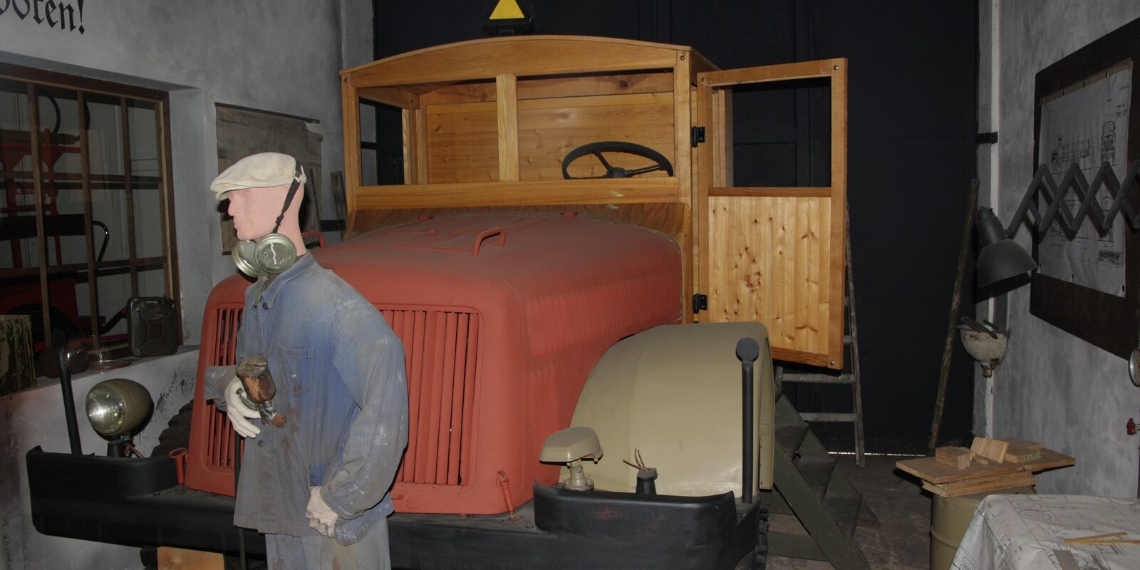 Těžký třínápravový vojenský nákladní automobil Tatra 111 v zeleném armádním nátěru v expozici muzea.